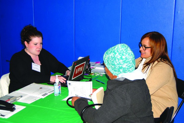 ➥ Lindsey de Masshealth y Anna traductora durante la feria de salud atendiendo a un cliente.