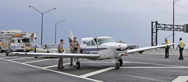 Agentes de la Patrulla de Carreteras de la Florida conversan con el propietario de la avioneta. Alan Díaz – AP