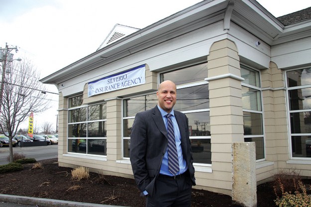 ➥➥ Evan Silverio posa en frente de la nueva oficina de Silverio Insurance Agency en el10 South Broadway, Lawrence, la cual fue establecida por sus padres Julia y José Darío Silverio hace 32 años.