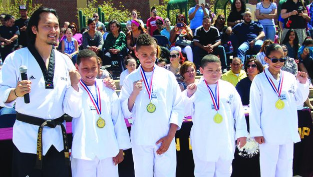 ➥➥ Master Hans Kim posa con estudiantes que ganaron medallas por mejorar académicamente desde que empezaron a participar en el programa de Taekwondo en la Escuela South Lawrence East School. Ellos son Luis Martínez, Daniel Torres, Anven Francisco y Jhonsy Perdomo.