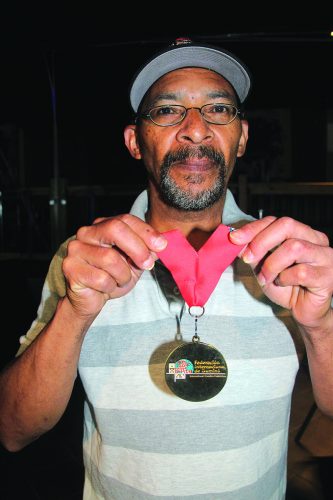 ➥➥ Franklyn Almonte muestra la medalla que ganó durante la competencia Mundial de Dominó en la Florida.