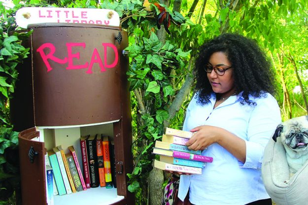 ➥➥ Verónica Piña coloca libros que donó a la biblioteca libre localizada en Jacques Pond en la calle Genesee al sur de Lawrence.