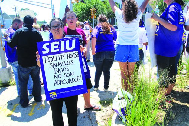➥➥ Nurys Cintrón agunta un cartelón pidiendole justicia laboral a Fidelity House.