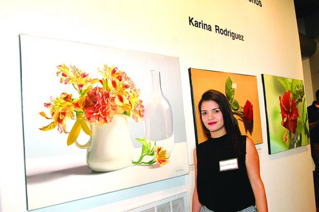 ➥➥ Karina Rodríguez posa delante de dos de sus obras en la exposición “Tonos Caribeños”.