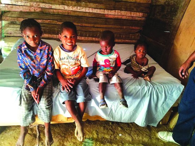 ➥➥ Niños que antes dormían en el suelo, están contentos porque recibieron como regalo la cama sobre la que están sentados.