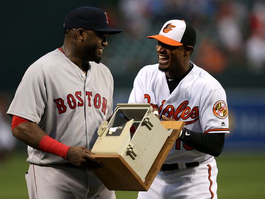Adam Jones (derecha) de los Orioles de Baltimore entrega a David Ortiz de los Medias Rojas de Boston con un teléfono que destruyó en la temporada de 2013, el jueves 22 de septiembre de 2016. Foto: AP