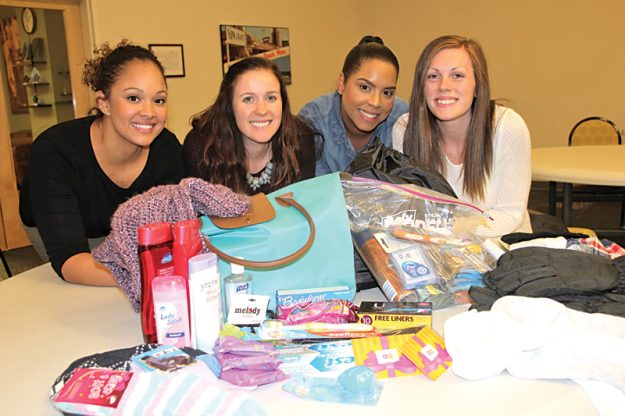 Yadira Váldez, Sylvia Martínez, Megan McKallagat y Ashley Cimino muestran algunos de los bolsos y sus contenidos. (Fotos por Yadira Betances)
