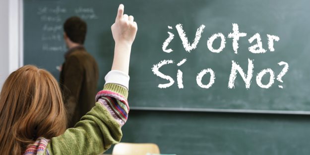 Rear view of a girl raising her hand in a classroom