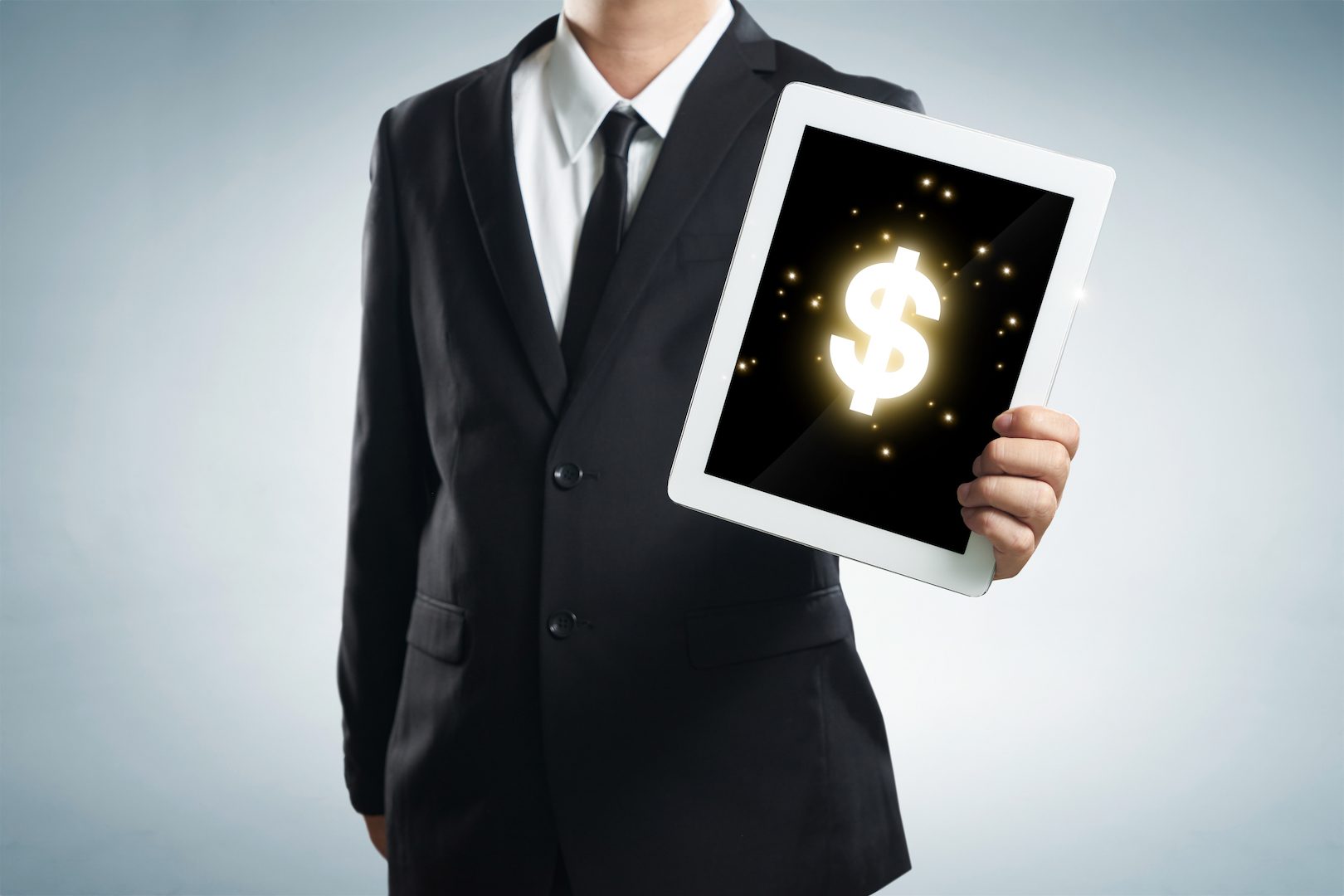 successful young businessman shows the screen of the tablet with dollar symbol