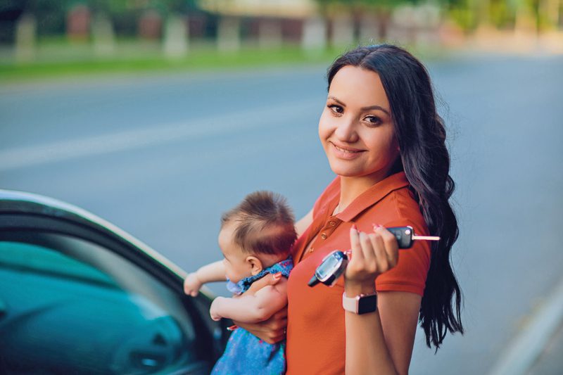 Mujer caminando a su carro con su bebe