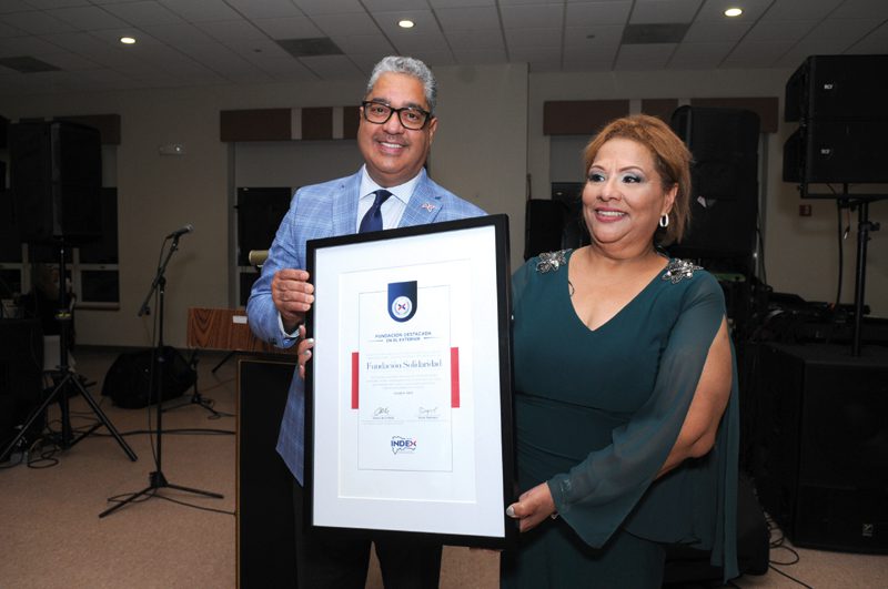Director de INDEX-Boston, Oscar Guerrero, entrega reconocimiento a comunicadora Milagros Marte.