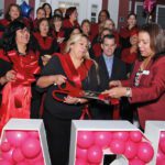 Frances Martínez, directora de la Asociación de Comerciantes Latinos del North Shore, hace el simbólico corte de cinta en presencia del alcalde Jared Nicholson y de todos los asistentes.